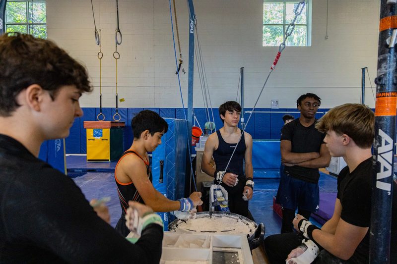 Arlington Tigers boys gymnastics team chalking up before practice at Barcroft