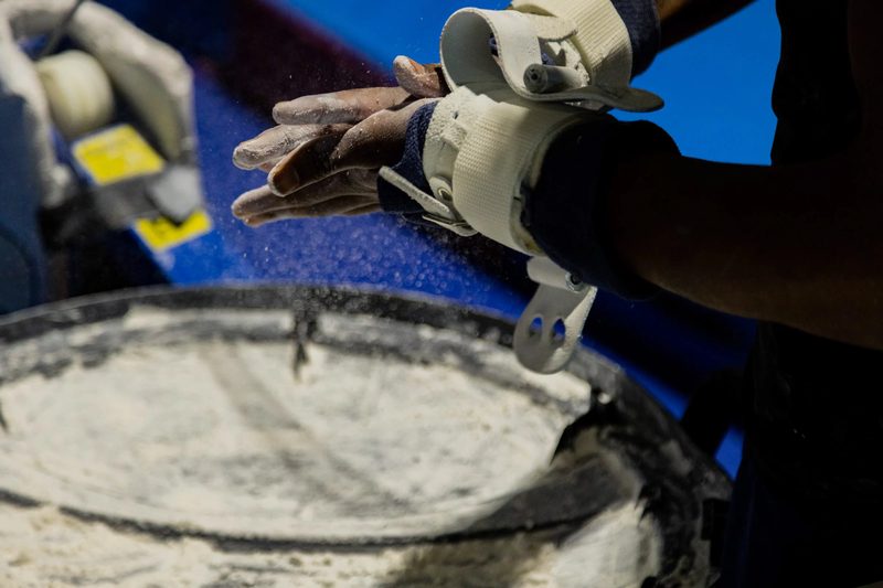 Close-up of Arlington Tigers gymnast chalking grips before training